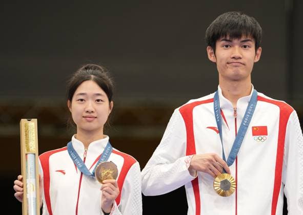 (240727) -- CHATEAUROUX, July 27, 2024 -- Huang Yuting (L) Sheng Lihao of China pose for photos during the awarding ceremony after the 10m air rifle mixed team gold medal match of shooting at the Paris 2024 Olympic Games, Olympische Spiele, Olympia, OS in Chateauroux, France, on July 27, 2024. Ju Huanzong) (PARIS2024)FRANCE-CHATEAUROUX-SHOOTING-10M AIR RIFLE MIXED TEAM-AWARDING CEREMONY juhuanzong 