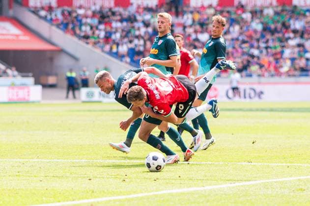 03.08.2024 - Fußball, 2024 2025, 2. Bundesliga, 1. Spieltag, Hannover 96 - SSV Jahn Regensburg: (L-R) Benedikt Saller (Regensburg), Fabian Kunze (Hannover) DFL REGULATIONS PROHIBIT ANY USE OF PHOTOGRAPHS AS IMAGE SEQUENCES AND OR QUASI-VIDEO.