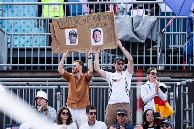 FRA, Paris, Olympischen Spiele Paris 2024, (03.08.2024, (Beachvolleyball Herren Achtelfinale, Eiffel Tower - Centre Court) Nils Ehlers (Deutschland, 1) und Clemens Wickler (Deutschland, 2) gegen George Souto Maior Wanderley (Brasilien, 1) und Andre Loyola Stein (Brasilien, 2) Fans mit Plakat Deutsche Kartoffeln auf die 1 Copyright: HMBxMedia SteffiexWunderl