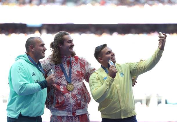 (240805) -- PARIS, Aug. 5, 2024 -- Gold medalist Ethan Katzberg (C) of Canada, silver medalist Bence Halasz (L) of Hungary and bronze medalist Mykhaylo Kokhan of Ukraine take selfies during the victory ceremony of the men s hammer throw of Athletics at the Paris 2024 Olympic Games, Olympische Spiele, Olympia, OS in Paris, France, Aug. 5, 2024. ) (PARIS2024) FRANCE-PARIS-OLY-ATHLETICS-HAMMER THROW-MEN LixYing 