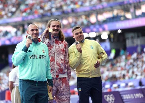 (240805) -- PARIS, Aug. 5, 2024 -- Gold medalist Ethan Katzberg (C) of Canada, silver medalist Bence Halasz (L) of Hungary and bronze medalist Mykhaylo Kokhan of Ukraine react during the victory ceremony of the men s hammer throw of Athletics at the Paris 2024 Olympic Games, Olympische Spiele, Olympia, OS in Paris, France, Aug. 5, 2024. ) (PARIS2024) FRANCE-PARIS-OLY-ATHLETICS-HAMMER THROW-MEN LixYing 
