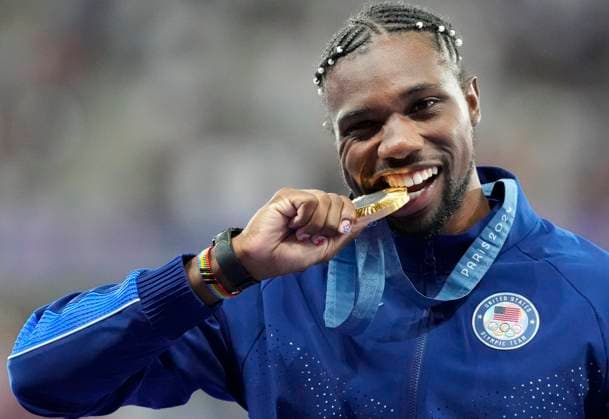 Men s 100m Final gold medalist Noah Lyles of the U.S. bites his medal on the podium at the Stade de France during the Paris 2024 Olympic Games, Olympische Spiele, Olympia, OS Athletics competition in Paris, France, on Monday, August 5, 2024.  OLY202408051673 PAULxHANNA