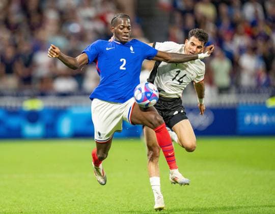(240805) -- LYON, Aug. 5, 2024 -- Castello Lukeba (L) of France vies with Zizo of Egypt during the men s simifinal match of football between France and Egypt of Paris 2024 Olympic Games, Olympische Spiele, Olympia, OS in Lyon, France, Aug. 5, 2024. ) (PARIS 2024)FRANCE-LYON-OLY-FOOTBALL SunxFei 