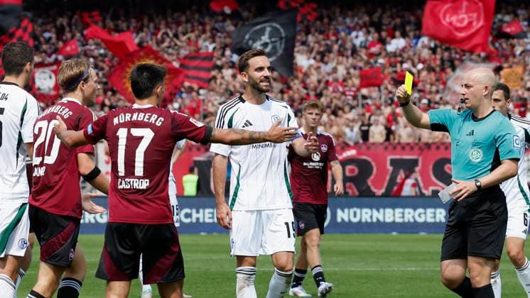 Schiedsrichter Nicolas Winter (re) zeigt Caspar Jander (1.FC Nuernberg, 20) die Gelbe Karte. 10.08.2024, Fussball, 2. Bundesliga, 2. Spieltag, 1. FC Nuernberg - FC Schalke 04, GER, Nuernberg, Max-Morlock-Stadion, DFL REGULATIONS PROHIBIT ANY USE OF PHOTOGRAPHS AS IMAGE SEQUENCES AND OR QUASI-VIDEO.