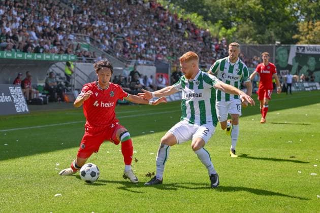 11.08.2024, Fussball, 2. Bundesliga, 2. Spieltag Saison 2024 2025, Preußen Münster - Hannover 96, Sei Muroya (Hannover 96), Mikkel Kirkeskov (SC Preussen Münster) xRHR-FOTO TKx