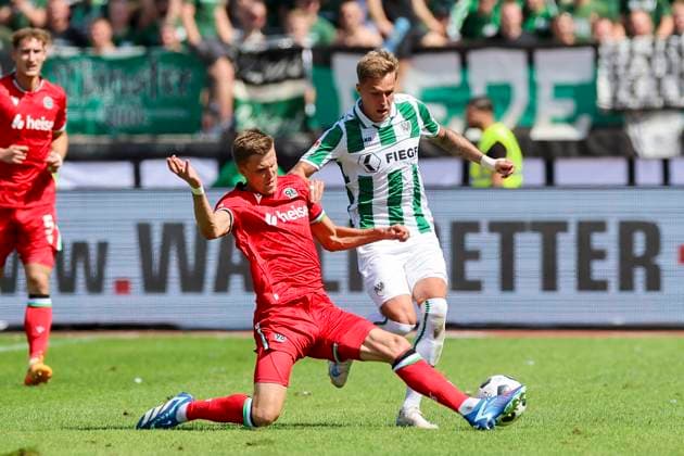 Fabian Kunze (Hannover 96) und Joel Grodowski (SC Preussen Muenster) kaempfen um den Ball, 2. Bundesliga, Preußen Münster vs Hannover 96, Preußenstadion, 11.08.2024, Münster, Deutschland.