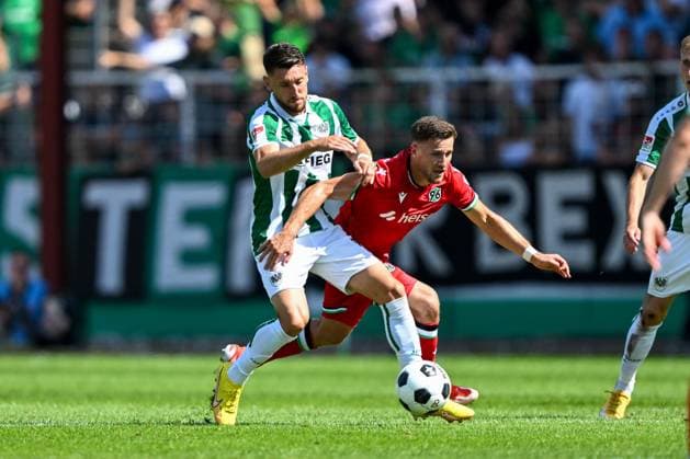 2. Bundesliga - SC Preußen Münster - Hannover 96 am 11.08.2024 im Preußenstadion in Münster Babis Makridis (Muenster) im Zweikampf gegen Enzo Leopold (Hannover 96)