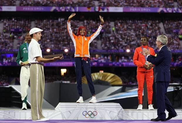 (240811) -- PARIS, Aug. 11, 2024 -- Gold medalist Sifan Hassan (C rear) of the Netherlands waves to the spectators as International Olympic Committee (IOC) President Thomas Bach (1st R) claps for her during the victory ceremony of women s marathon of Athletics at the closing ceremony of the Paris 2024 Olympic Games, Olympische Spiele, Olympia, OS in Paris, France, Aug. 11, 2024. ) (PARIS2024) FRANCE-PARIS-OLY-CLOSING CEREMONY LixMing 