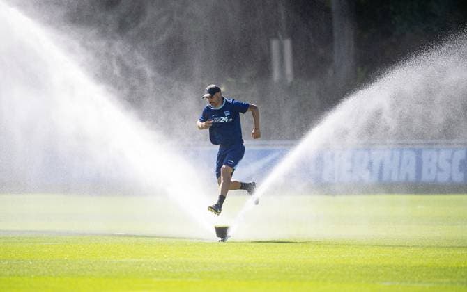 Fussball, Herren, Saison 2024 25, 2. Bundesliga, Hertha BSC, Training, Trainer Cristian Fiel (Hertha BSC) springt über einen Rasensprenger, 13.08. 2024,