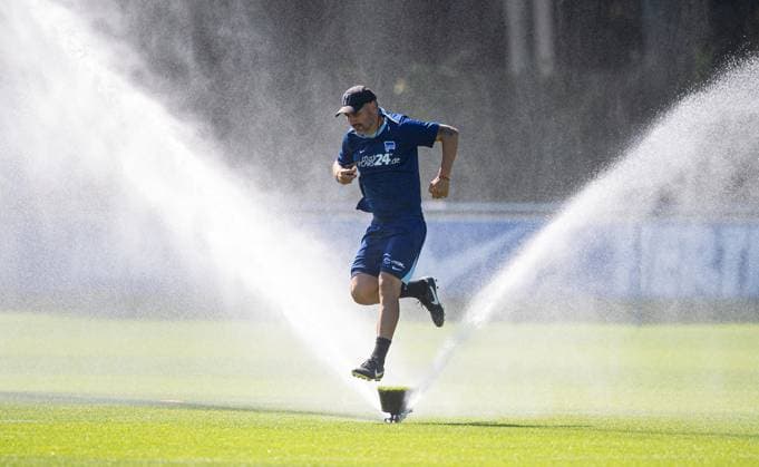 Sport Bilder des Tages Fussball, Herren, Saison 2024 25, 2. Bundesliga, Hertha BSC, Training, Trainer Cristian Fiel (Hertha BSC) springt über einen Rasensprenger, 13.08. 2024,