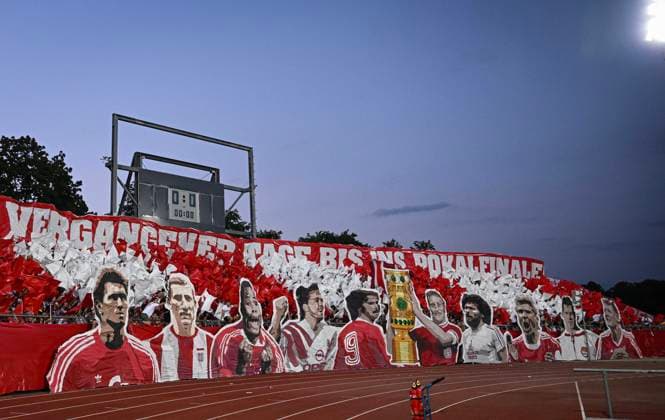 Fussball DFB Pokal 2024 2025 1. Runde 16.08.2024 SSV Ulm - FC Bayern Muenchen FC Bayern Fan Choreo im Gaesteblock des Ulmer Donaustadion, mit Bildern von FCB Legenden Klaus Augenthaler, Hans-Georg, Katsche, Schwarzenbeck, Samuel Osei, Sammy, Kuffour, Lothar Matthaeus, Gerd Mueller, Werner Olk mit Pokal, Paul Breitner, Stefan Effenberg, Franz Beckenbauer und Bastian Schweinsteiger (v.li.)