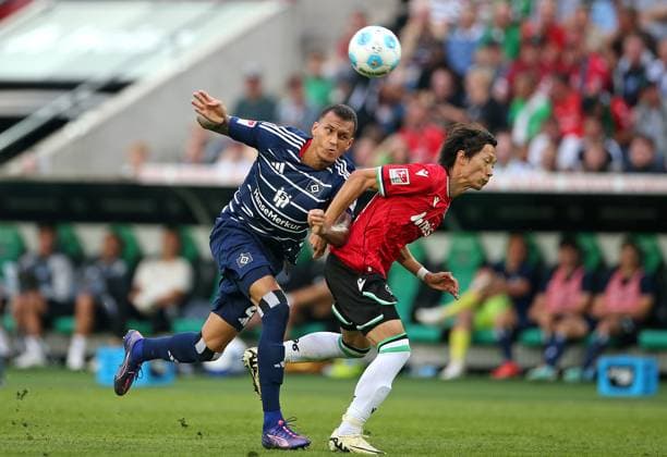 23.08.2024, Fussball 2. Bundesliga 2024 2025, 3. Spieltag, Hannover 96 - Hamburger SV, in der Heinz von Heiden Arena Hannover. (L-R) Davie Selke (Hamburg) gegen Sei Muroya (Hannover)
