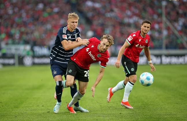 23.08.2024, Fussball 2. Bundesliga 2024 2025, 3. Spieltag, Hannover 96 - Hamburger SV, in der Heinz von Heiden Arena Hannover. (L-R) Adam Karabec (Hamburg) gegen Jannik Dehm (Hannover)