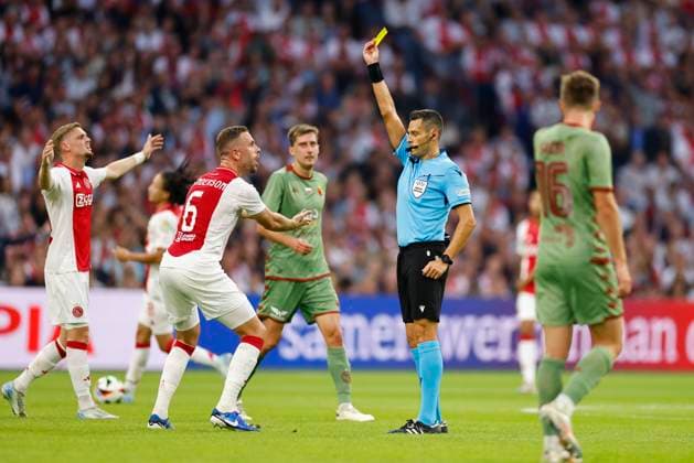 AMSTERDAM, 29-08-2024 , JohanCruyff Arena, Europa League Play Offs, season 2024 2025, Ajax- Jagiellonia Bialystok. ;lr Ajax player Jordan Henderson yellow card, referee Maurizo Mariani (ITA) Ajax - Jagiellonia Bialystok  x26143228x Copyright: