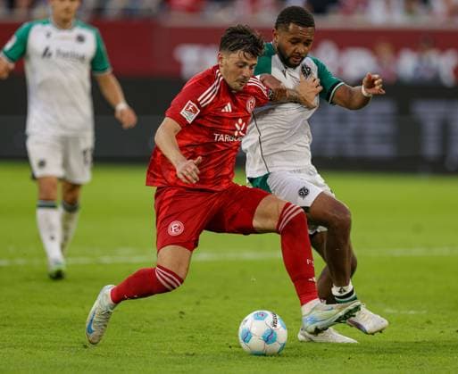 Düsseldorf, Deutschland, 30.08.24: Dawid Kownacki (Fortuna Düsseldorf) und Brooklyn Ezeh (Hannover 96) im Kampf um den Ball waehrend des 2. Bundesliga Spiels zwischen Fortuna Düsseldorf vs Hannover 96 in der Merkur Spiel Arena am 30. August 2024 in Düsseldorf, Deutschland. (Foto von Stefan Brauer Brauer-Fotoagentur) Düsseldorf, Germany, 30.08.24: Dawid Kownacki (Fortuna Düsseldorf) und Brooklyn Ezeh (Hannover 96) battle for the ball during the 2. Bundesliga match between Fortuna Düsseldorf vs Hannover 96 at Merkur Spiel Arena on August 30, 2024 in Düsseldorf, Germany. (Photo by Stefan Brauer Brauer-Fotoagentur) DFB DFL REGULATIONS PROHIBIT ANY USE OF PHOTOGRAPHS AS IMAGE SEQUENCES AND OR QUASI-VIDEO. Düsseldorf Merkur Spiel Arena North Rhine-Westphalia Germany