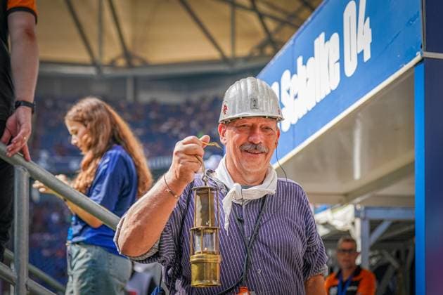 Fußball: 2. Bundesliga Saison 2024 - 2025, 4. Spieltag - FC Schalke 04 vs. 1. FC Köln - Veltins-Arena, Gelsenkirchen: Kumpel mit Bergwerks Lampe