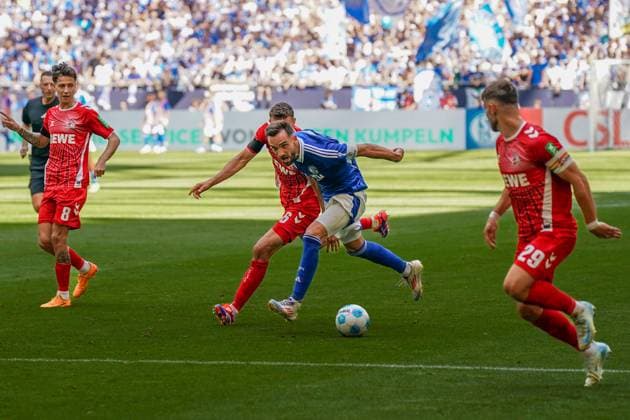 Fußball: 2. Bundesliga Saison 2024 - 2025, 4. Spieltag - FC Schalke 04 vs. 1. FC Köln - Veltins-Arena, Gelsenkirchen: Schalkes Kenan Karaman vor dem Kölner Tor umgeben von Kölns Eric Martel, Kölns Denis Huseinbasic und Kölns Jan Thielmann