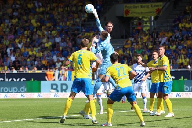 01.09.2024, xtgx, Fussball 2. Bundesliga, Eintracht Braunschweig - Karlsruher SC emspor, v.l. Lennart Grill (Braunschweig, 1), Budu Zivivadze (Karlsruhe, 11) Parade, haelt den Ball, faengt den Ball, pariert Zweikampf, Duell, Kampf, tackle (DFL DFB REGULATIONS PROHIBIT ANY USE OF PHOTOGRAPHS as IMAGE SEQUENCES and or QUASI-VIDEO) Braunschweig