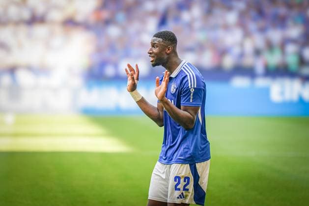 Fußball: 2. Bundesliga Saison 2024 - 2025, 4. Spieltag - FC Schalke 04 vs. 1. FC Köln - Veltins-Arena, Gelsenkirchen: Schalkes Ibrahima CissÃ Cisse bekommt von Schiedsrichter Sven Jablonski die Gelbe Karte