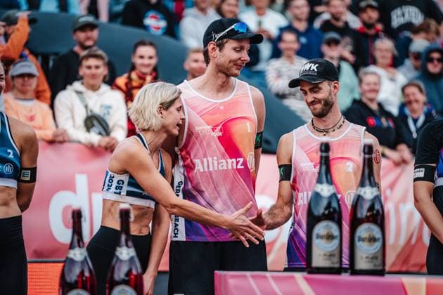 Beachvolleyball Frauen und Männer Allianz German Beach Tour Deutsche Beachvolleyball-Meisterschaft 2024 01.09.2024 links Laura Ludwig und rechts Clemens Wickler geben sich die Hand, in der Mitte Nils Ehlers Timmendorfer Strand Ahmann-Hager-Arena Schleswig-Holstein Deutschland