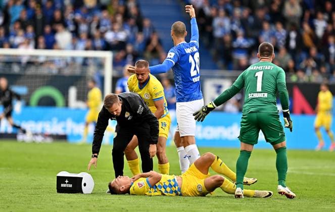 14.09.2024, xfux, Fussball 2.Bundesliga, SV Darmstadt 98 - Eintracht Braunschweig, v.l. Marvin Rittmüller Rittmueller (Eintracht Braunschweig), Sven Köhler Koehler (Eintracht Braunschweig) receive an injury, bursied, harried, hurt, injured, injury, trauma, disappointed, crestfallen, verletzt, Verletzung am Boden und bekommt keine Luft, Aleksandar Vukotic (SV Darmstadt 98), Marcel Schuhen (SV Darmstadt 98) gibt Anweisungen, gestikuliert, mit den Armen gestikulieren gives instructions, gesticulate, gesticolando. (DFL DFB REGULATIONS PROHIBIT ANY USE OF PHOTOGRAPHS as IMAGE SEQUENCES and or QUASI-VIDEO. Eine Lizenzierung des Lichtbildwerkes an und oder durch den SV Darmstadt 1898 e.V. sowie Tochterunternehmen ist nicht gestattet. No release of or sale to SV Darmstadt 1898 e.V.)) Darmstadt