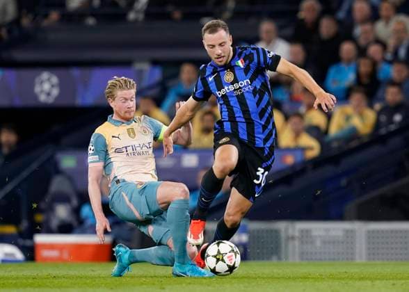 Manchester, England, 18th September 2024. Kevin De Bruyne of Manchester City tackles Carlos Augusto of Inter Milan during the UEFA Champions League match at the Etihad Stadium, Manchester. Picture credit should read: Andrew Yates Sportimage EDITORIAL USE ONLY. No use with unauthorised audio, video, data, fixture lists, club league logos or live services. Online in-match use limited to 120 images, no video emulation. No use in betting, games or single club league player publications. SPI-3321-0034
