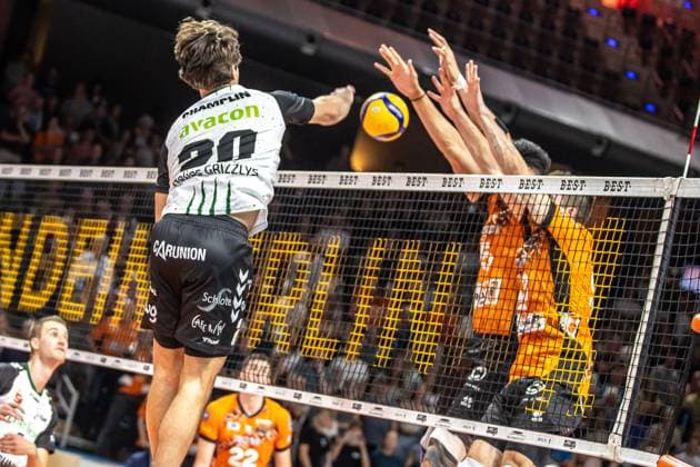 21.09.2024, Berlin, Volleyball: 1.Bundesliga, Maenner, 1. Spieltag, BR Volleys - Helios Grizzlys Giesen, Max-Schmeling-Halle. Ethan Champlin (l-r) von Helios Grizzlys Giesen spielt den Ball gegen den Block aus Berlins Nehemiah Mote und Ruben Schott. BR Volleys - Helios Grizzlys Giesen