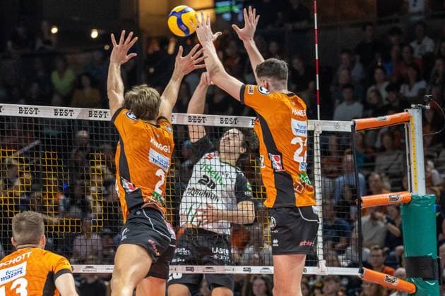 21.09.2024, Berlin, Volleyball: 1.Bundesliga, Maenner, 1. Spieltag, BR Volleys - Helios Grizzlys Giesen, Max-Schmeling-Halle. Ethan Champlin (M) von Helios Grizzlys Giesen spielt den Ball gegen Berlins Block aus Matthew Knigge (l) und Jake Hanes. BR Volleys - Helios Grizzlys Giesen