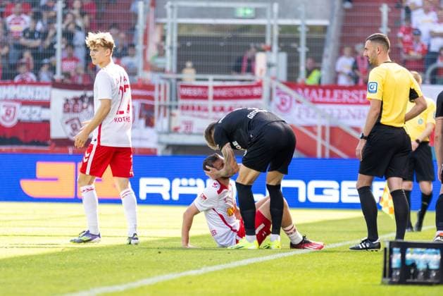 22.09.2024, Fussball, GER, Saison, 2.Liga, Saision 2024 2025, 6. Spieltag, - SSV Jahn Regensburg - SC Preußen Münster Joel Grodowski entschuldigt sich bei Oscar Schönfelder (SSV Jahn Regensburg) nach dem Foul DFL REGULATIONS PROHIBIT ANY USE OF PHOTOGRAPHS AS IMAGE SEQUENCES AND OR QUASI-VIDEO. Regensburg Bayern Deutschland Jahnstadion Regensburg