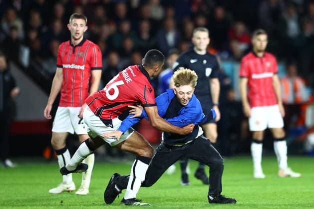 Sport Themen der Woche KW39 Sport Bilder des Tages Walsall v Leicester City EFL Cup 24 09 2024. Walsall midfielder Ronan Maher (16) tackles a picth invader during the EFL Cup match between Walsall and Leicester City at the Poundland Stadium, Walsall, England on 24 September 2024. Walsall Poundland Stadium West Midlands England Editorial use only DataCo restrictions apply See www.football-dataco.com , Copyright: xJohnxMallettx PSI-20472-0053