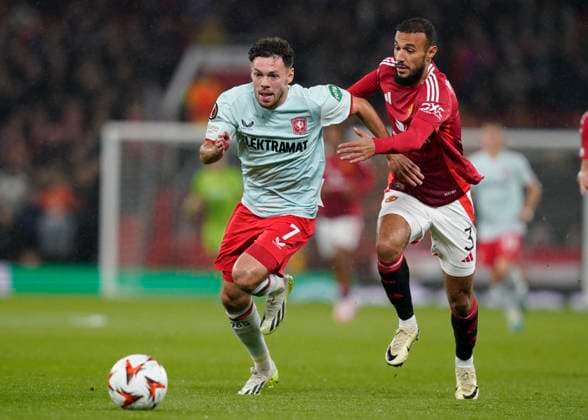 Manchester, England, 25th September 2024. Twente s Mitchell van Bergen gets past Noussair Mazraoui of Manchester United, ManU during the UEFA Europa League match at Old Trafford, Manchester. Picture credit should read: Andrew Yates Sportimage EDITORIAL USE ONLY. No use with unauthorised audio, video, data, fixture lists, club league logos or live services. Online in-match use limited to 120 images, no video emulation. No use in betting, games or single club league player publications. SPI-3332-0025