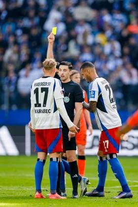 Hamburg, 28. September 2024 - Fußball, 2. Bundesliga 2024 25, Hamburger SV - SC Paderborn 07: Schiedsrichter Florian Badstübner (Nürnberg) zeigt Adam Karabec (Hamburger SV, 17) die gelbe Karte DFL REGULATIONS PROHIBIT ANY USE OF PHOTOGRAPHS AS IMAGE SEQUENCES AND OR QUASI-VIDEO.