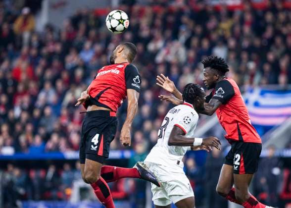 Leverkusen, Bayarena, 01.10.2024: Jonathan Tah of Leverkusen (L) jumps for a header against Tammy Abraham of Mailand during Champions League Spiel Bayer 04 Leverkusen vs. AC Mailand.