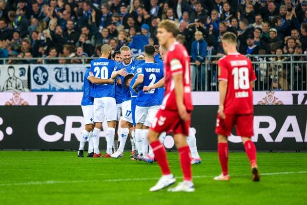 Fraser Hornby (SV Darmstadt 98, 09) und Team bejubeln das Tor zum 1:0, Timo Huebers (1. FC Koeln, 04) und Rasmus Carstensen (1. FC Koeln, 18) sind enttauescht, GER, SV Darmstadt 98 vs. 1. FC Koeln, Fussball, 2. Bundesliga, 9. Spieltag, Saison 2024 2025, 18.10.2024. DFL REGULATIONS PROHIBIT ANY USE OF PHOTOGRAPHS as IMAGE SEQUENCES and or QUASI-VIDEO. GER, SV Darmstadt 98 vs. 1. FC Koeln, Fussball, 2. Bundesliga, 9. Spieltag, Saison 2024 2025, 18.10.2024. Darmsatdt