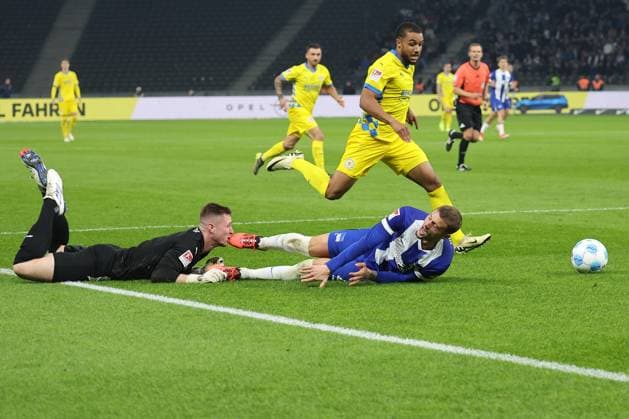 Berlin, 18.10.24, Fussball, 2.Bundesliga, 9. Spieltag, Hertha BSC - Eintracht Braunschweig, Olympiastadion. Torwart Lennart Grill von Eintracht Braunschweig kaempft gegen Berlins Mickal Cuisance um den Ball. DFL regulations and DFB regulations prohibit any use of photographs as image sequences and or quasi-video, Foto: Andreas Gora Hertha BSC - Eintracht Braunschweig