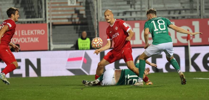 Alem Japaur (Mitte, Würzburg) im Duell mit Kevin Fery (am Boden, Nr. 15) und Luca Trslic (beide Schweinfurt); Fußball, Regionalliga Bayern, Saisn 2024 25, FC Würzburger Kickers - 1. FC Schweinfurt 05 1:0 (0:0), 18.101.2024, Arkon Arena, Stadion am Dallenberg, Würzburg