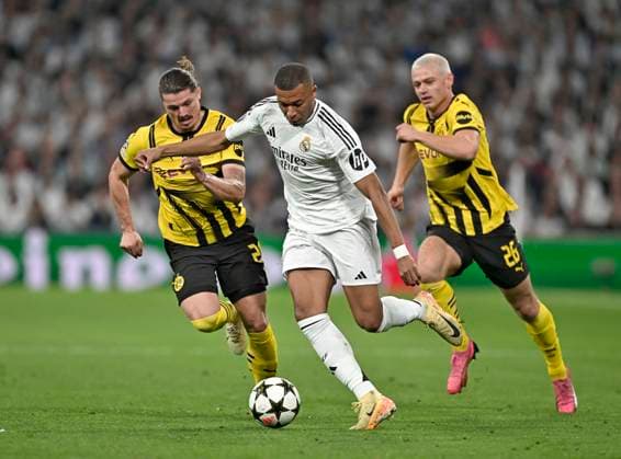 22.10.2024, Fussball UEFA Champions League 2024 2025, 3.Spieltag, Real Madrid - Borussia Dortmund, im Estadio Santiango Bernabeu in Madrid (Spanien), v.l. Marcel Sabitzer (Borussia Dortmund), Kylian Mbappe (Real Madrid) und Julian Ryerson (Borussia Dortmund) im Duell um den Ball.