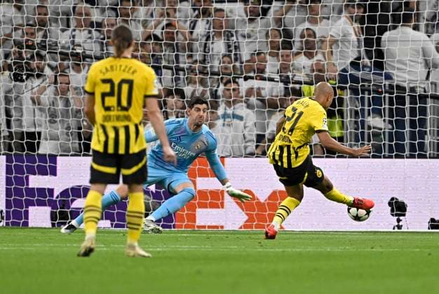 22.10.2024, Fussball UEFA Champions League 2024 2025, 3.Spieltag, Real Madrid - Borussia Dortmund, im Estadio Santiango Bernabeu in Madrid (Spanien), Donyell Malen (Borussia Dortmund) trifft zum 0:1 gegen Torwart Thibaut Courtois (Real Madrid)