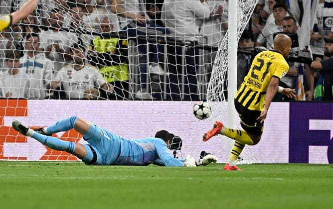 22.10.2024, Fussball UEFA Champions League 2024 2025, 3.Spieltag, Real Madrid - Borussia Dortmund, im Estadio Santiango Bernabeu in Madrid (Spanien), Donyell Malen (Borussia Dortmund) trifft zum 0:1 gegen Torwart Thibaut Courtois (Real Madrid)
