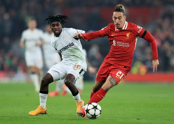 5th November 2024; Anfield, Liverpool, Merseyside, England; Champions League Football, Liverpool versus Bayer Leverkusen; Kostas Tsimikas of Liverpool holds off a challenge from Jeremie Frimpong of Bayer Leverkusen  ActionPlus12712534 DavidxBlunsden