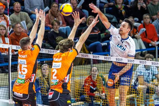 23.11.2024, Berlin, Volleyball, Maenner: DVV-Pokal, Viertelfinale, BR Volleys - SVG Lueneburg, Max-Schmeling-Halle. Xander Ketrzynski (r-l) von SVG Lueneburg spielt den Ball durch Berlins Block aus Matthew Knigge und Moritz Reichert. BR Volleys - SVG Lueneburg