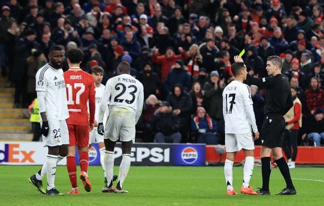 27th November 2024; Anfield, Liverpool, Merseyside, England; Champions League Football, Liverpool versus Real Madrid; referee Francois Letexier shows a yellow card to Ferland Mendy of Real Madrid for his foul on Mohammed Salah of Liverpool  ActionPlus12720721 DavidxBlunsden