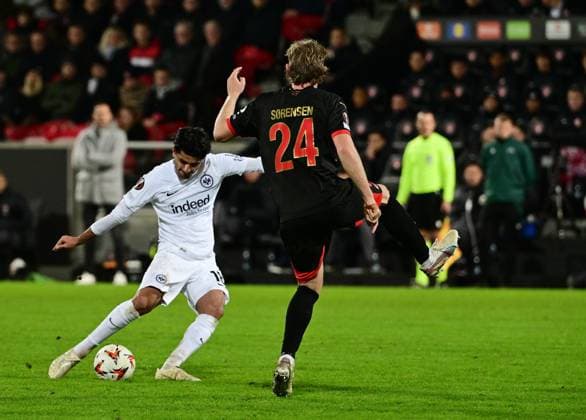 28.11.2024, xmnx, Fussball UEFA Europa League, FC Midtyilland - Eintracht Frankfurt emspor, v.l. Mahmoud Dahoud (Eintracht Frankfurt), Oliver Soerensen (FC Midtjylland) (UEFA REGULATIONS PROHIBIT ANY USE OF PHOTOGRAPHS as IMAGE SEQUENCES and or QUASI-VIDEO) Herning