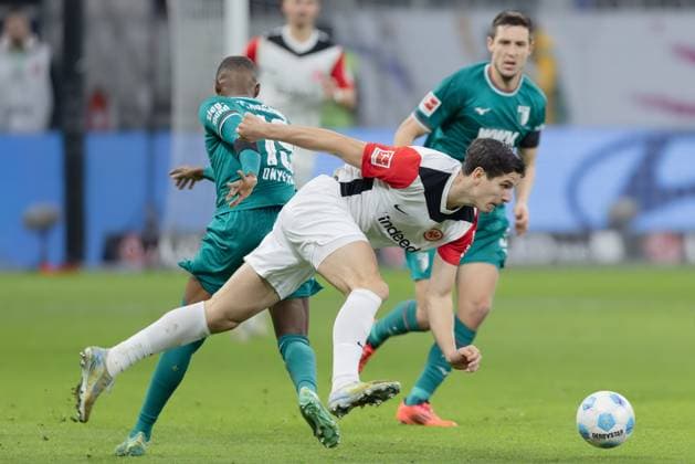 Eintracht Frankfurt - FC Augsburg, 1. FBL Nach einer Attacke von Frank Onyeka (FC Augsburg, 19) gerät Igor Matanovic (Eintracht Frankfurt, 9) ins Straucheln Bundesligaspiel zwischen Eintracht Frankfurt und dem FC Augsburg am 7. Dezember 2024 im Deutsche Bank Park in Frankfurt am Main. Nach Vorgaben der DFL, Deutsche Fußball Liga, ist es untersagt, in dem Stadion und oder vom Spiel angefertigte Fotoaufnahmen in Form von Sequenzbildern und oder videoähnlichen Fotostrecken zu verwerten bzw. verwerten zu lassen., Frankfurt am Main Hessen Deutschland Deutsche Bank Park