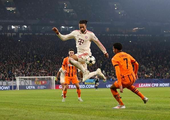 10.12.2024, Fussball UEFA Champions League 2024 2025, 6.Spieltag, Schachtar Donezk - FC Bayern München, in der Veltins-Arena Gelsenkirchen. Michael Olise (FC Bayern München) in der Luft. re: Eguinaldo (Schachtar Donezk)