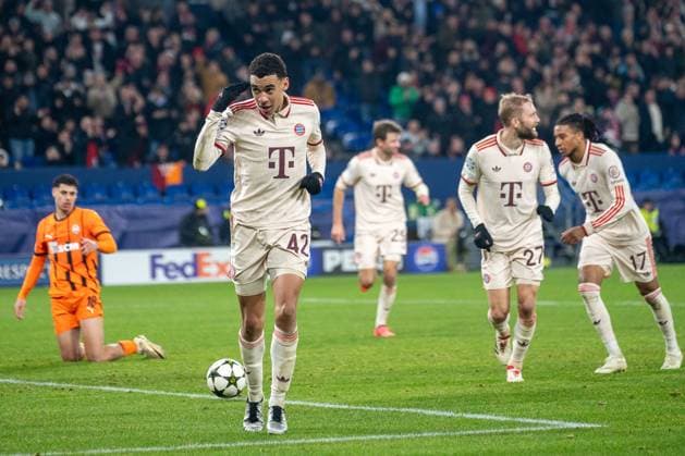 10.12.2024, Fussball: UEFA Champions League, Saison 2024 2025, Spieltag 06, Shakhtar Donetsk - FC Bayern Muenchen in der Veltins-Arena in Gelsenkirchen. Waehrend sich Jamal Musiala (FC Bayern Muenchen, 42), Konrad Laimer (FC Bayern Muenchen, 27) und Michael Olise (FC Bayern Muenchen, 17) ueber das Tor zum 4:1 freuen ist Alaa Ghram (Shakhtar Donetsk, 18) enttaeuscht. Foto: Kirchner-Media TH Copyright: xKirchner-Media THx