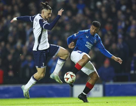 Hamza Igamane of Rangers in action with Radu Draguin of Tottenham Hotspur during the UEFA Europa League group phase match at Ibrox Stadium, Glasgow. Rangers v Tottenham Hotspur, UEFA Europa League, Football, Ibrox Stadium, Glasgow, Scotland, UK - 12 Dec 2024 EDITORIAL USE ONLY No use with unauthorised audio, video, data, fixture lists, club league logos or live services. Online in-match use limited to 120 images, no video emulation. No use in betting, games or single club league player publications. Copyright: xLukexNickerson RangersxFC Shutterstockx 14998163c