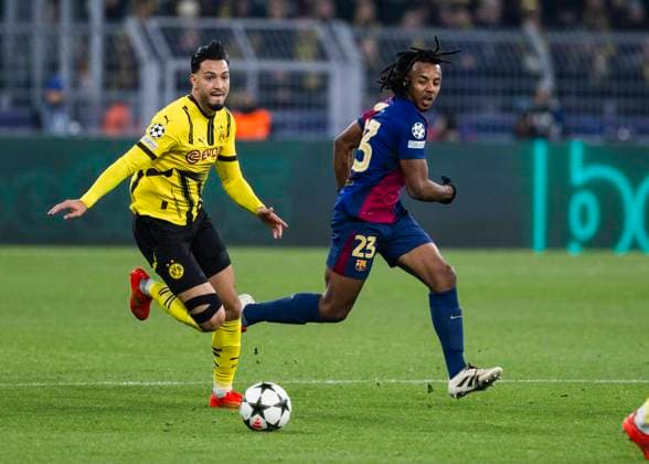 Signal-Iduna-Park, Dortmund, 11.12.2024: Emre Can of Dortmund challenges Jules KoundÃ of Barcelona during the Championsleague match Borussia Dortmund vs. FC Barcelona, Barca