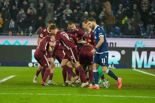 2. Bundesliga: Karlsruher SC vs SSV Jahn Regensburg Das Team von Jahn Regensburg das ihre Torhüter Felix Gebhardt (SSV Jahn Regensburg 1) feiern nach dem gehobenen Elfmeter, im Vordergrund der enttäuschte Budu Zivzivadze (Karlsruher SC 11) 2. Bundesliga: Karlsruher SC vs SSV Jahn Regensburg, BBBank Wildpark, Freitag 13.12.2024