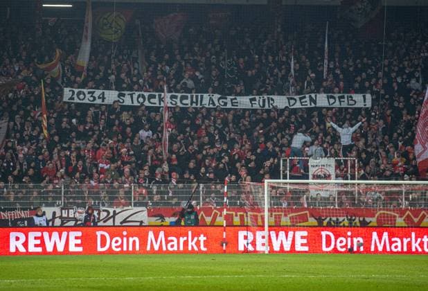 Fussball, Herren, Saison 2024 2025, 1. Bundesliga (14. Spieltag), 1. FC Union Berlin - VfL Bochum, Fans von Union protestieren gegen die Vergabe der Weltmeisterschaft nach Saudi-Arabien: 2034 Stockschläge für den DFB!, 14.12.2024, Copyright: xSebastianxRäppold MatthiasxKochx